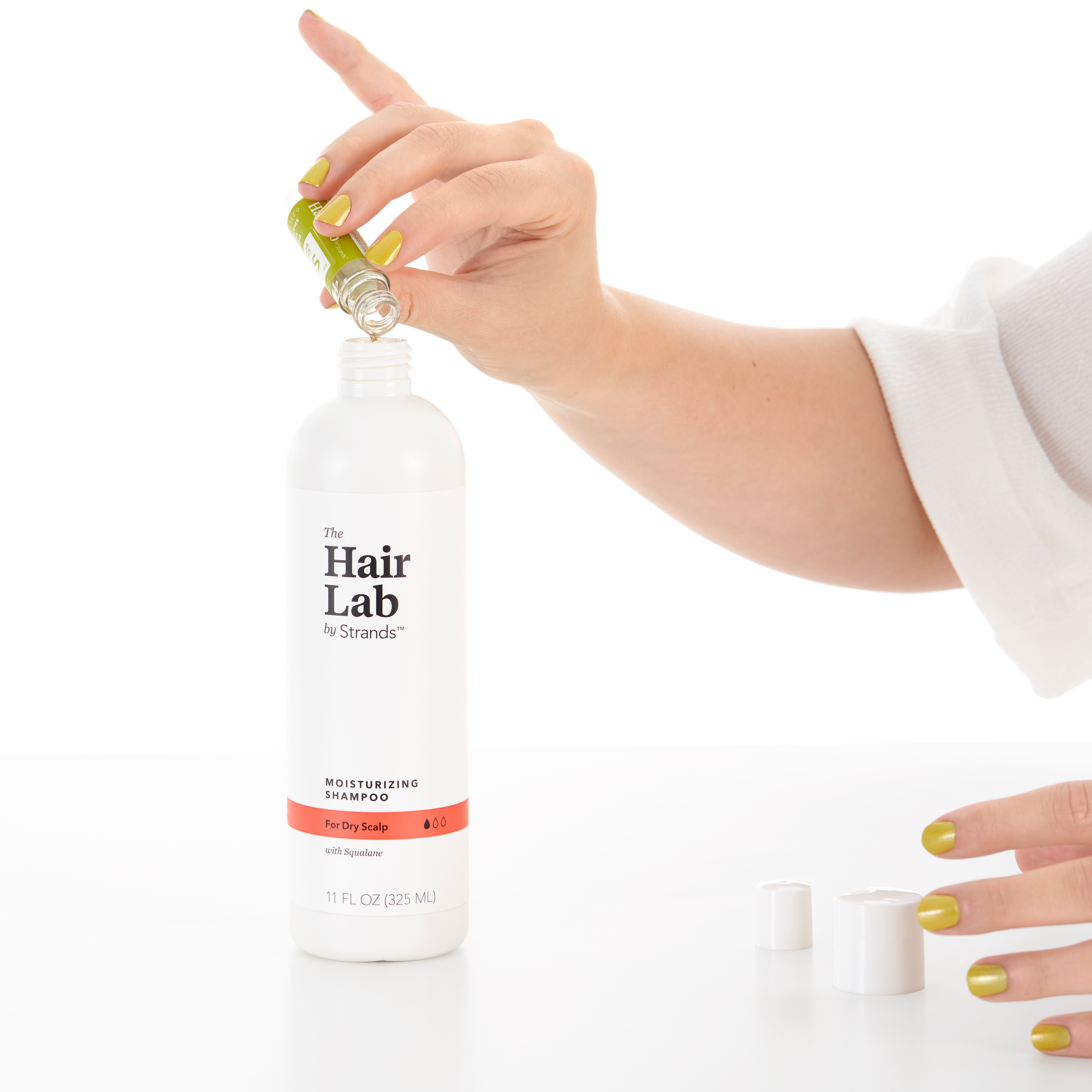 The Hair Lab by Strands personalized hair care dose being poured into paraben-free shampoo